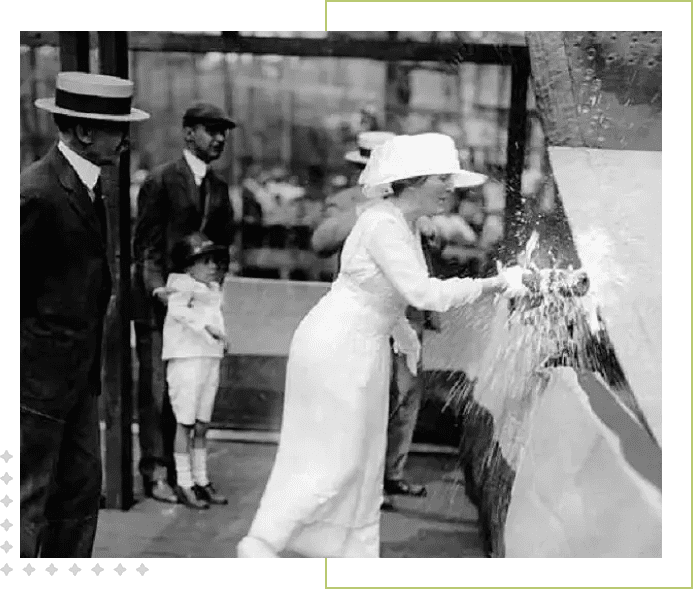 A woman in white dress and hat is cutting paper.