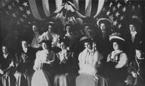 A group of people in front of an american flag.