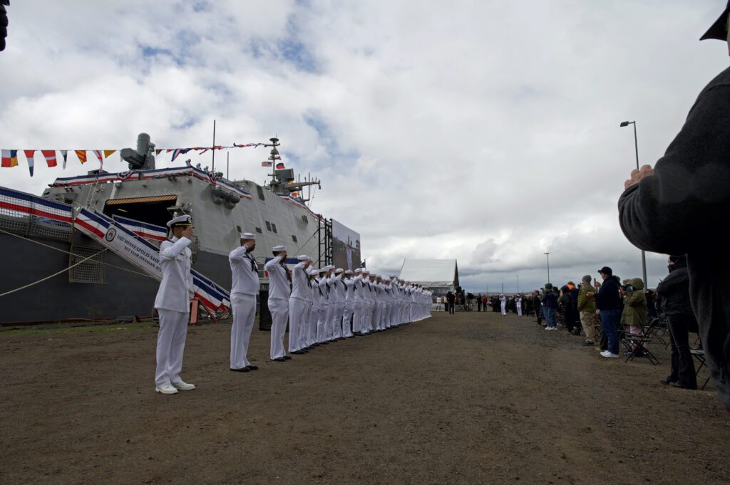 DULUTH, Minnesota (May 21, 2021) Sailors salute the audience during the commissioning ceremony of the Freedom-variant littoral combat ship USS Minneapolis-Saint Paul (LCS 21) in Duluth, Minnesota. Minneapolis-Saint Paul is the second U.S. Navy warship to honor the Twin Cities. (U.S. Navy photo by Mass Communication Specialist 2nd Class Sonja Wickard)