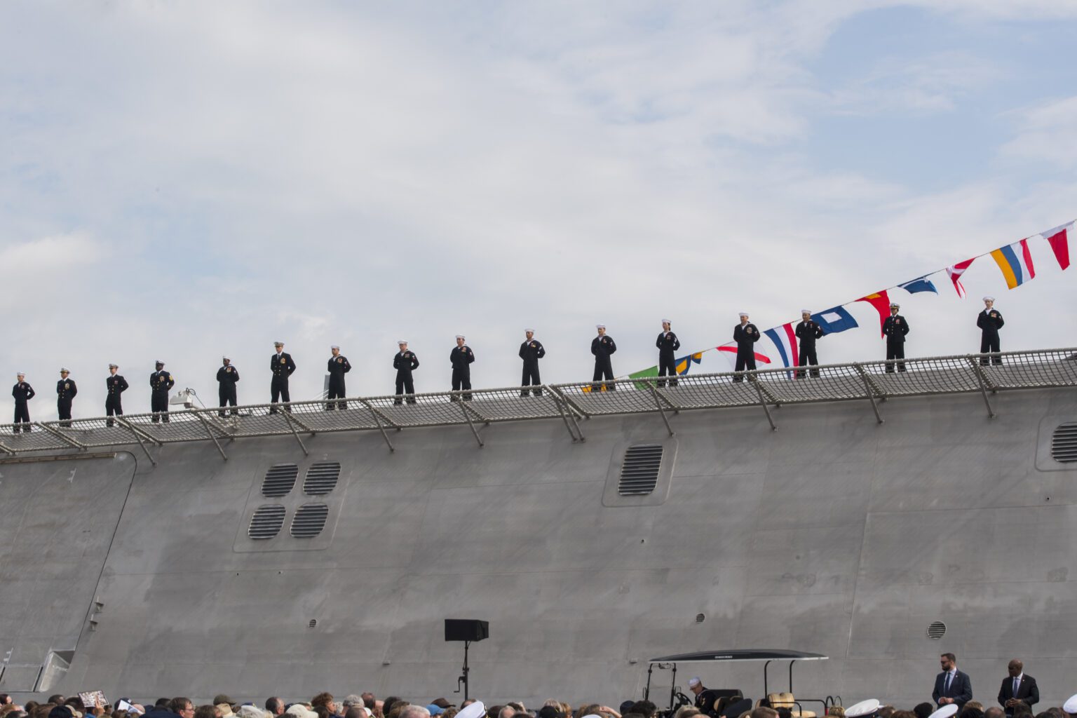 Sailors standing on warship at ceremony.