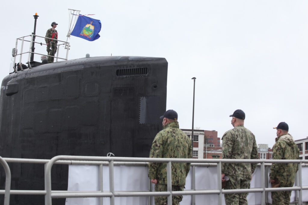 The assistant navigator informs the commanding officer, executive officer and chief of the boat that the commissioning pennant has been fully raised aboard USS Vermont (SSN 792), bringing the ship to life during a small commissioning ceremony held by the crew. Vermont is the 19th Virginia-class fast-attack submarine. In photo, from left on the top of the sail to right, Senior Chief Electronics Technician (SS) Shawn Mason, assistant navigator; Electronics Technician Seaman Joshua Ragan; Lt. Austin Thompson, weapons officer; Lt. Cmdr. Martín Roschmann, executive officer; Cmdr. Charles W. Phillips III, commanding officer. (U.S. Navy photo by Mark Jones/Released)