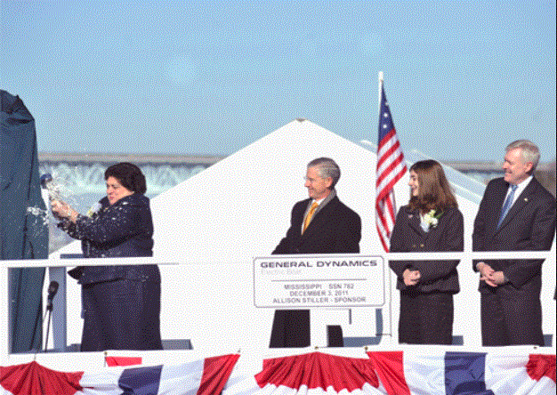 Ship christening ceremony with four people present.